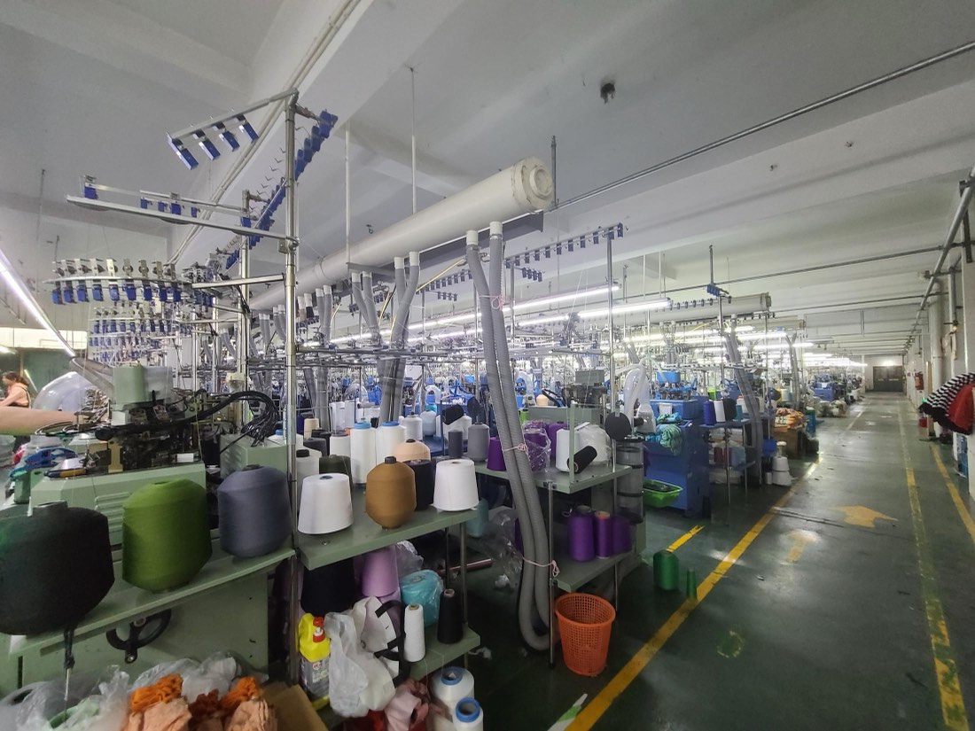Knitting hall with circular sock machines and yarn cones